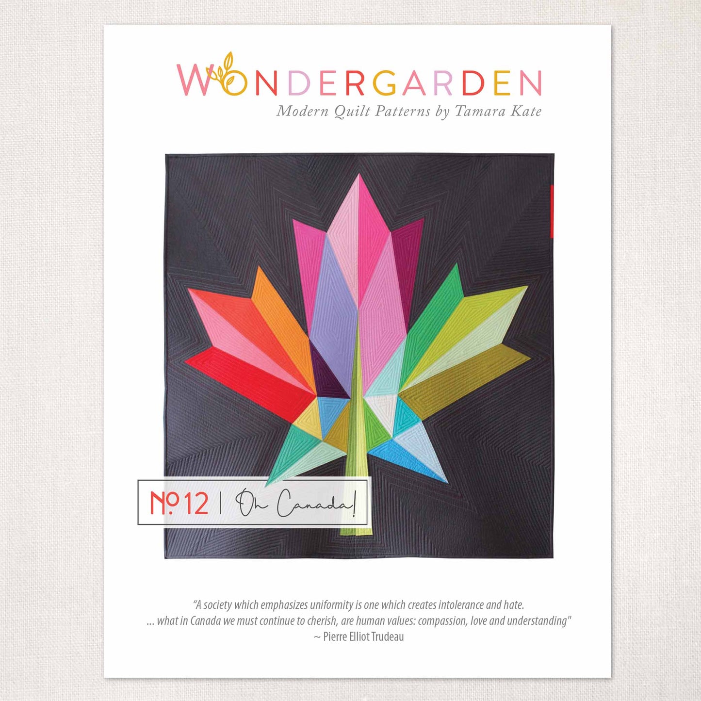 quilt pattern of a modern bold maple leaf in multi colours on a dark grey ground