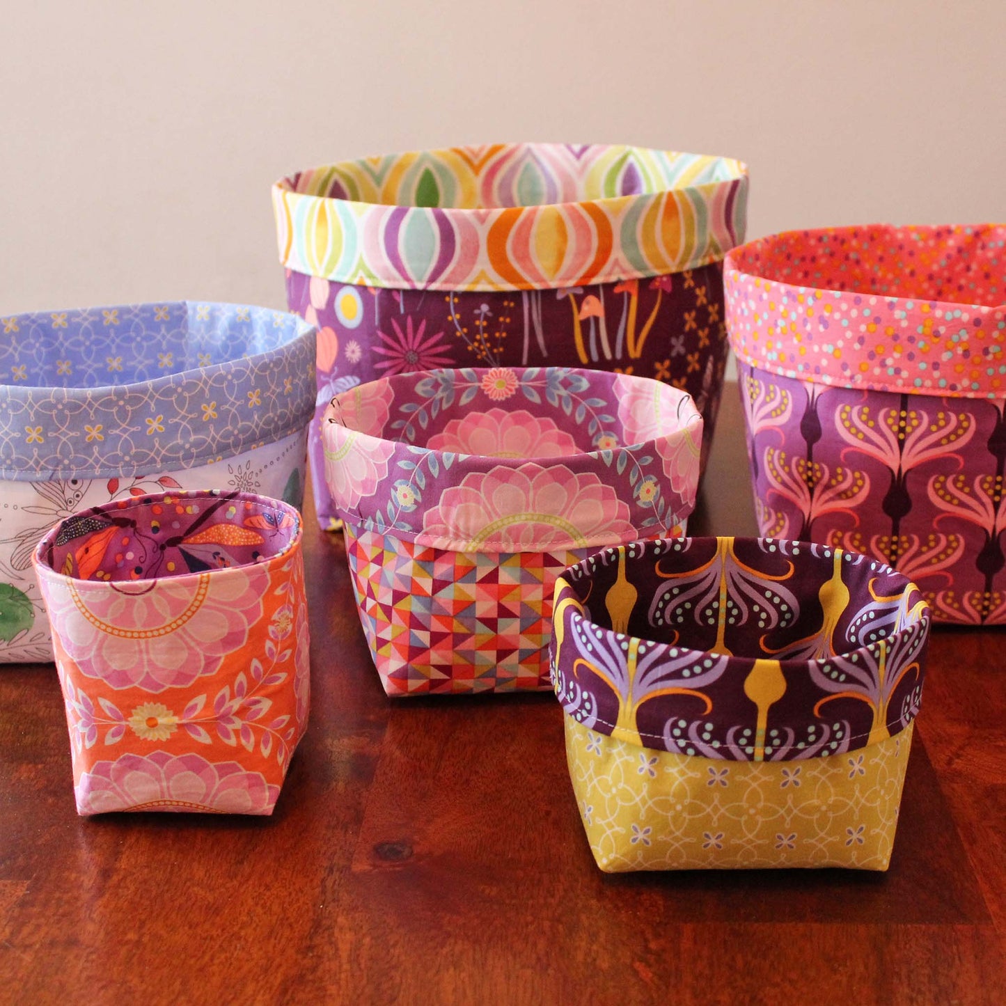 fabric nesting baskets in various sizes and fabrics on a wooden surface