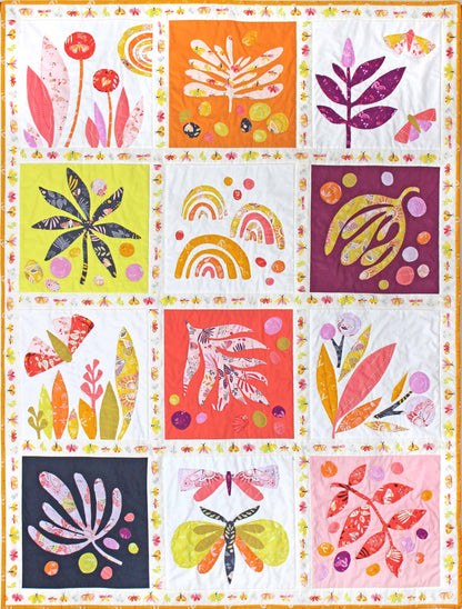 quilt of 12 warm coloured squares with abstract leaves and butterflies appliquéd.